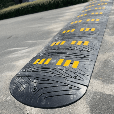 Zwarte rubberen verkeersdrempel van 7 cm met gele reflecterende strepen, geschikt voor vrachtwagens.